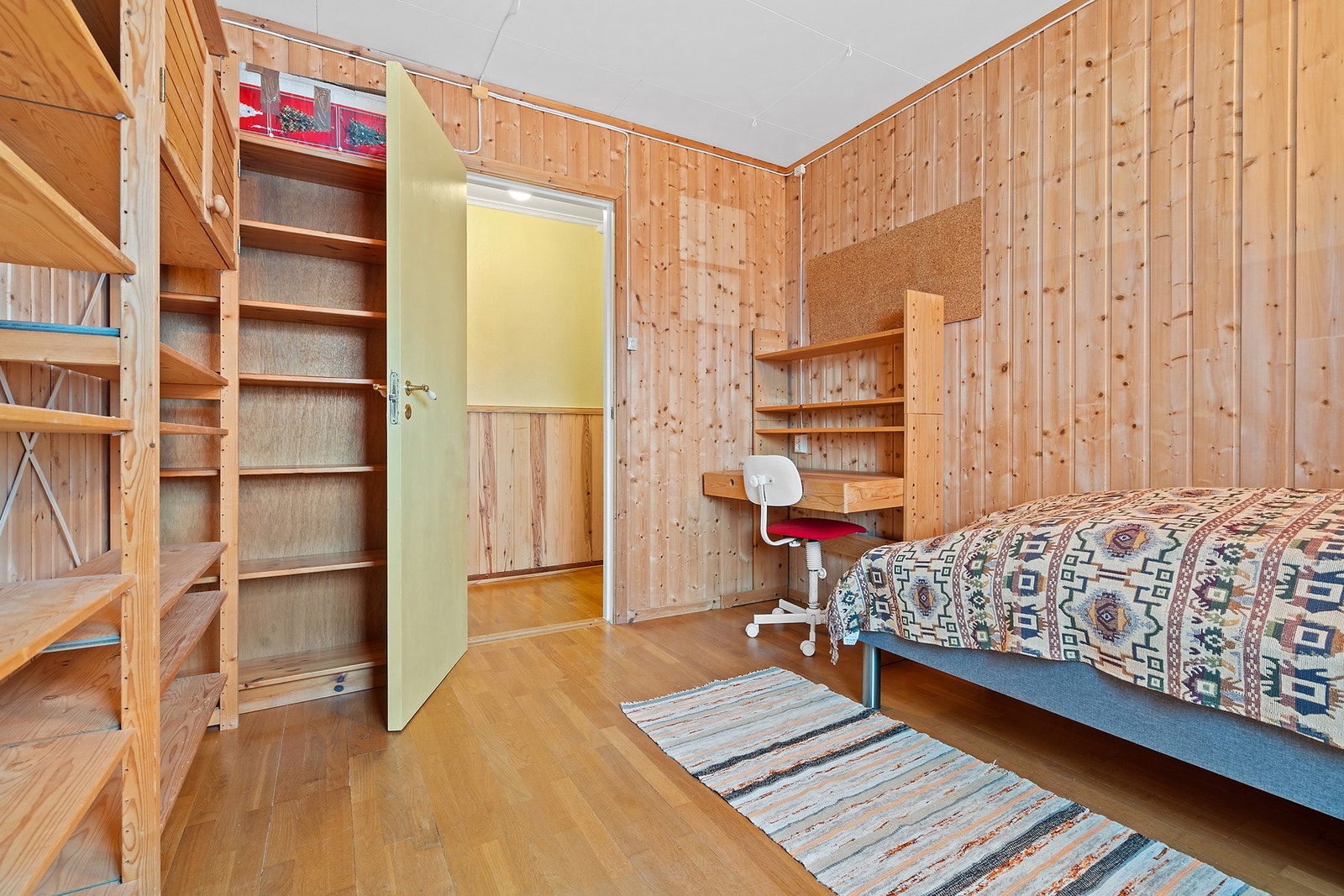 Rommet har parkett på gulv og vegger kledd med trepanel. Galleribilde