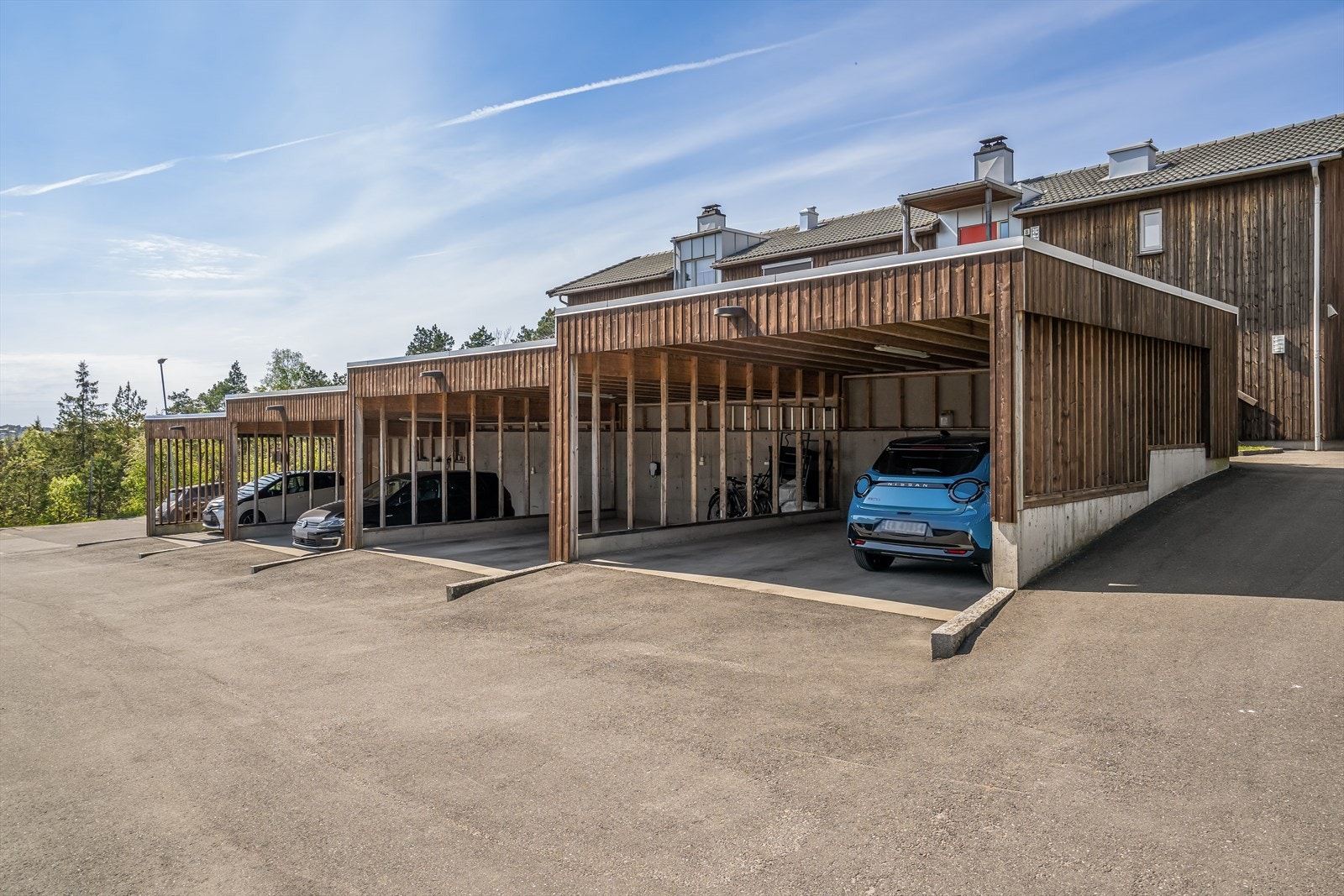 Parkering for en bil i felles carportanlegg som er utstyrt med el-billader. Galleribilde