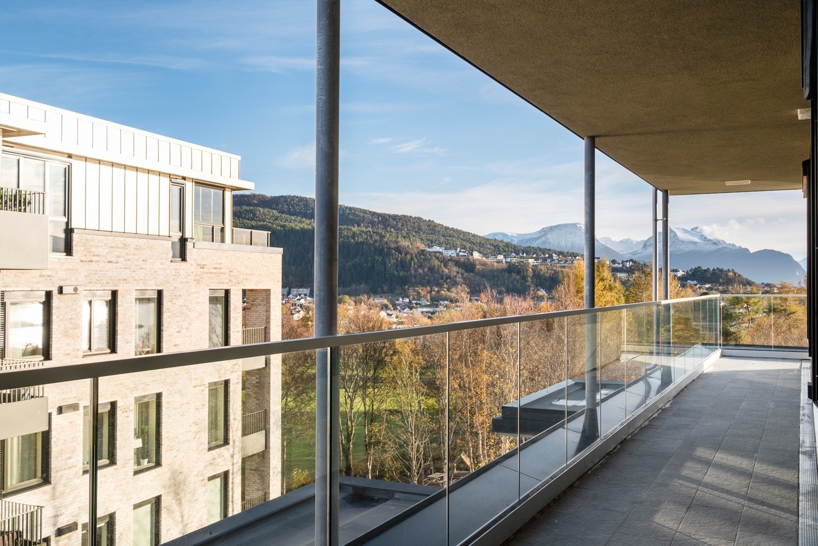 Den romslige balkongen har glassrekkverk og utsyn mot naturskjønne omgivelser. Galleribilde