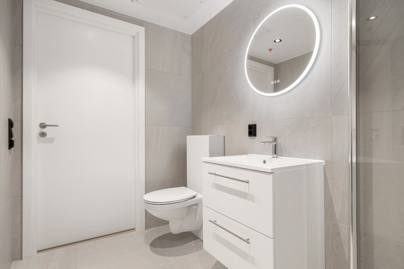 Badets innredning inkluderer en elegant servant og vegghengt toalett. Galleribilde