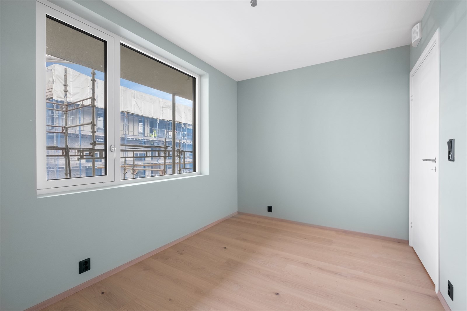 Det er et lyst og romslig område med malte vegger og parkettgulv. Galleribilde