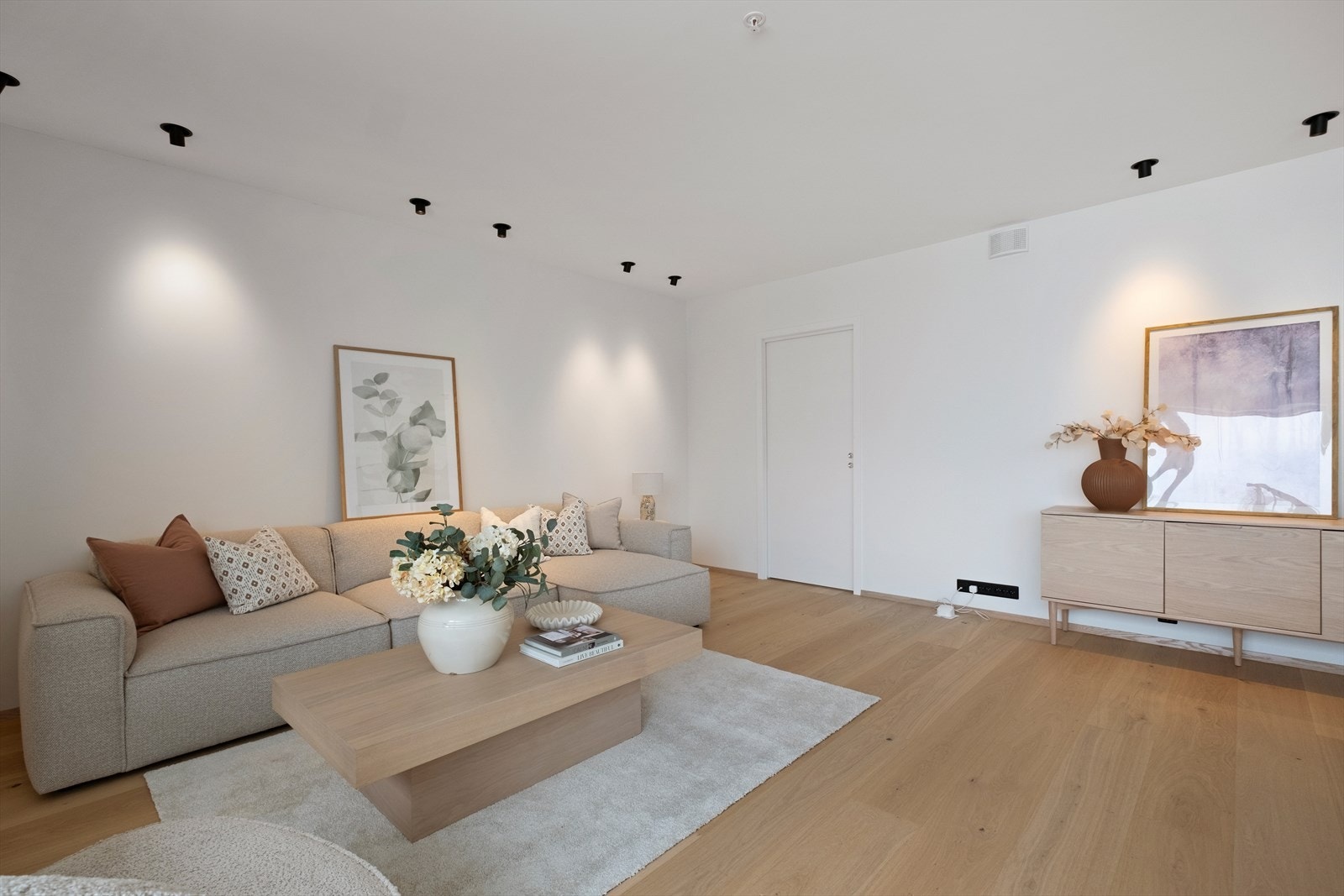 Oppholdsrommet har en moderne utforming med romslig planløsning og slettmalte vegger. Galleribilde