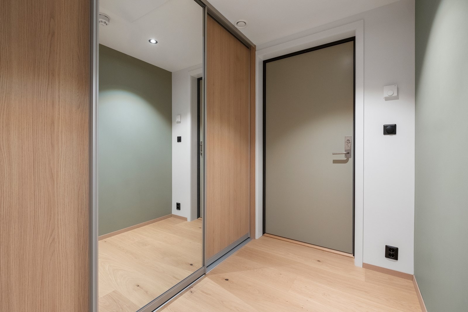 Gulvet har en lys og moderne parkett, og rommet har en praktisk skyvedørsgarderobe. Galleribilde