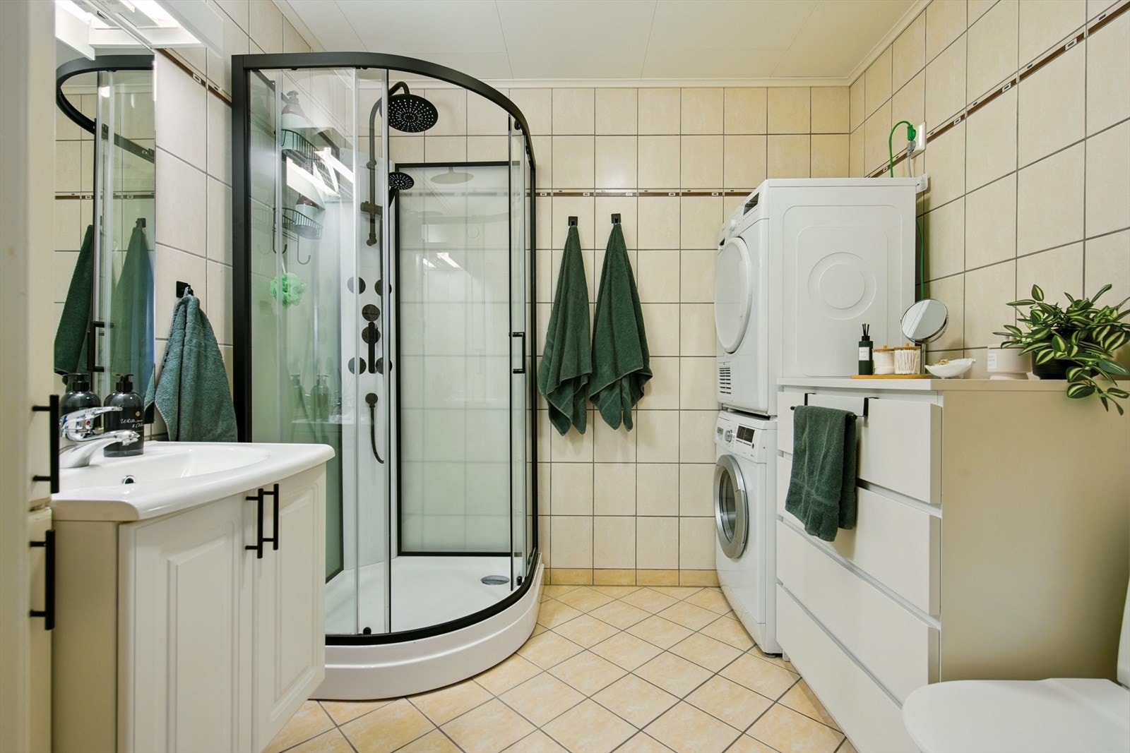 Badet er helfliset og har dusjkabinett, gulvvarme og opplegg for vaskemaskin. Galleribilde