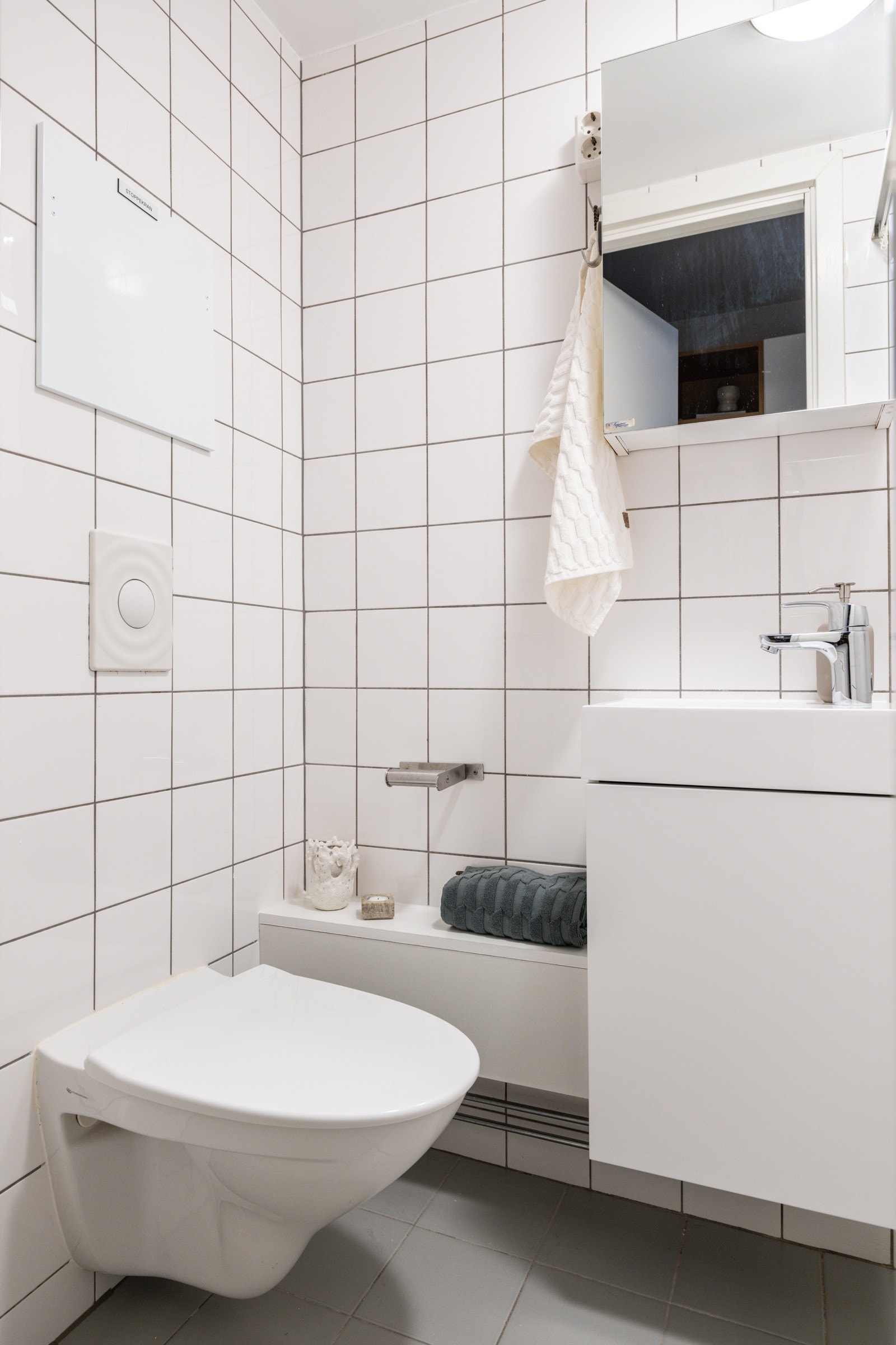 Baderommet er utstyrt med lyst servantskap med speilskap over, dusjnisje med delevegg og vegghengt toalett. Galleribilde