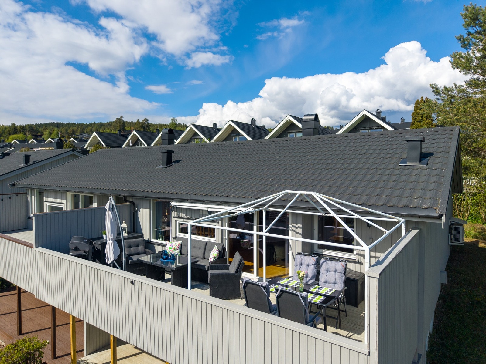 Stor og solrik terrasse med flere sitteområder og god plass til både avslapning og uteservering. Galleribilde