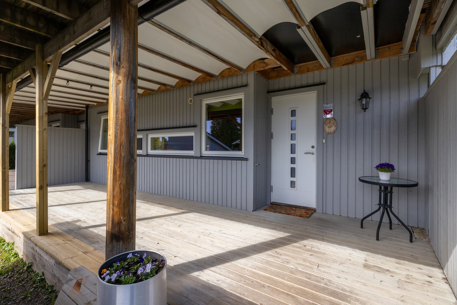 Overbygd terrasse med tredekke og inngangsparti. Galleribilde