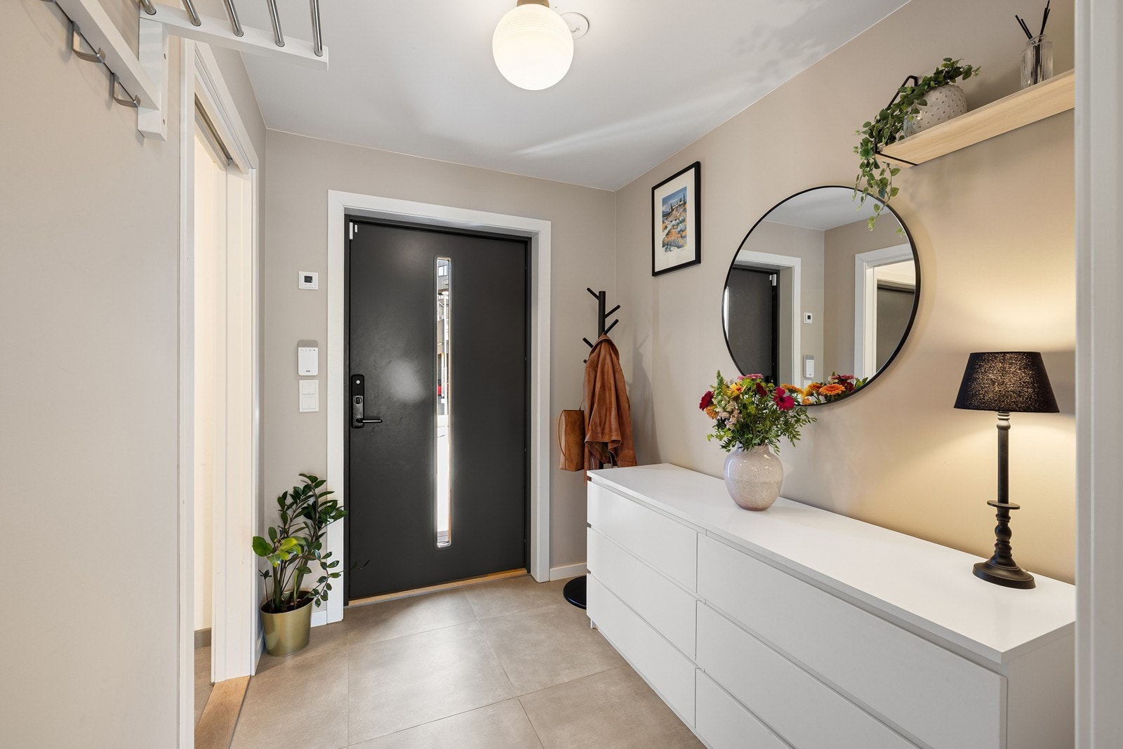 Inne i entréen er det plass til å henge fra seg yttertøy, samt å sette fra seg sko. Det er fliser på gulvet. Galleribilde
