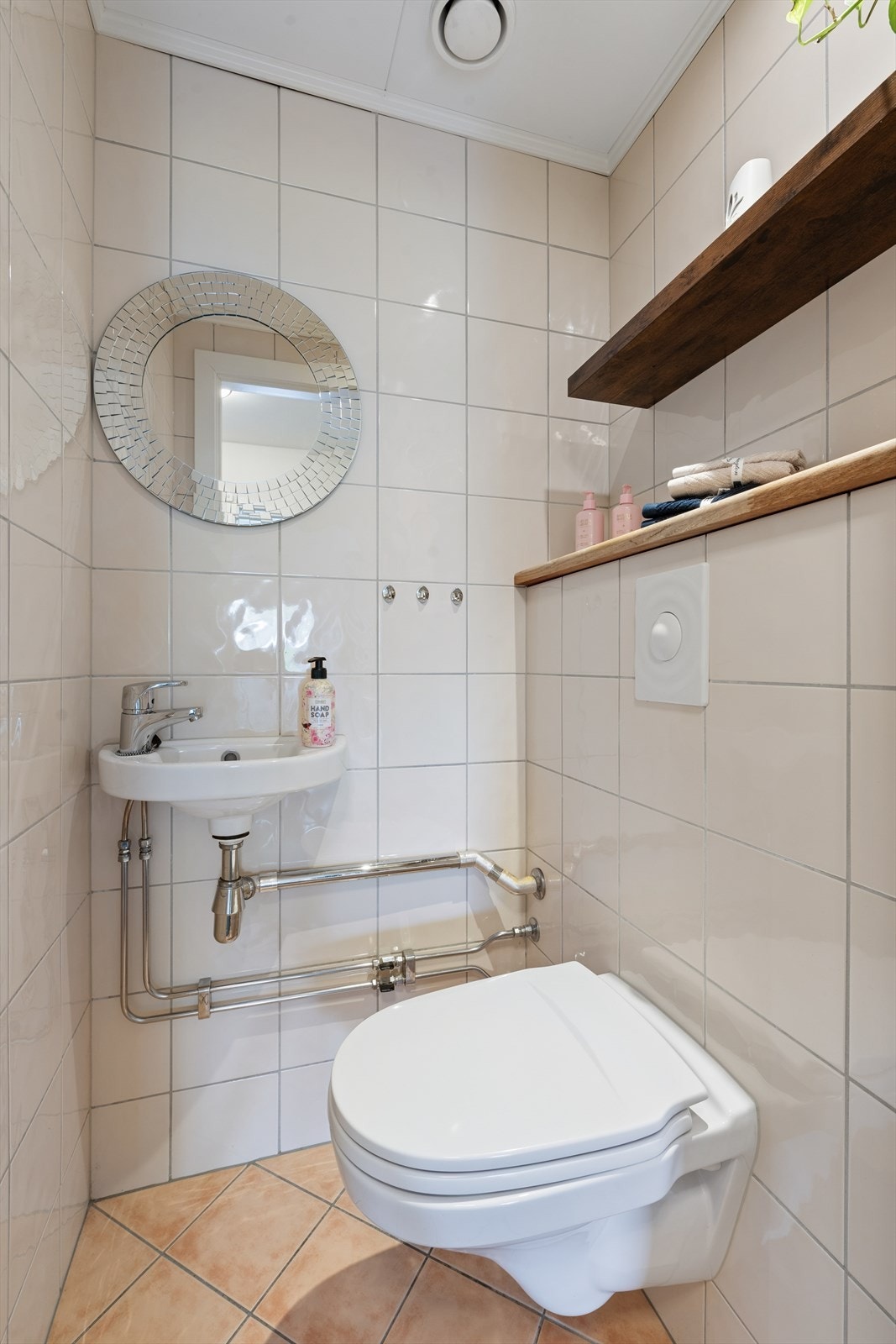 Separat wc-rom pusset opp i regi av borettslaget, utstyrt med toalett og praktisk servant. Galleribilde