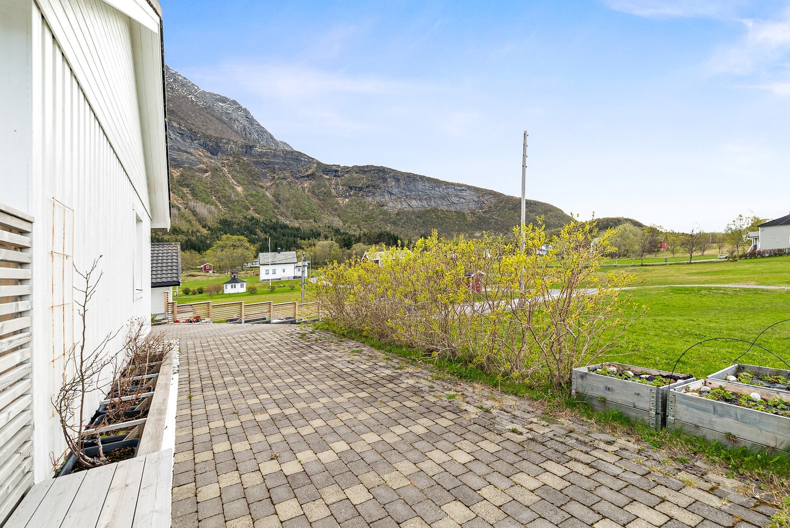 Gårdsplassen er belagt med belegningsstein, og oppkjørselen er gruset. Galleribilde