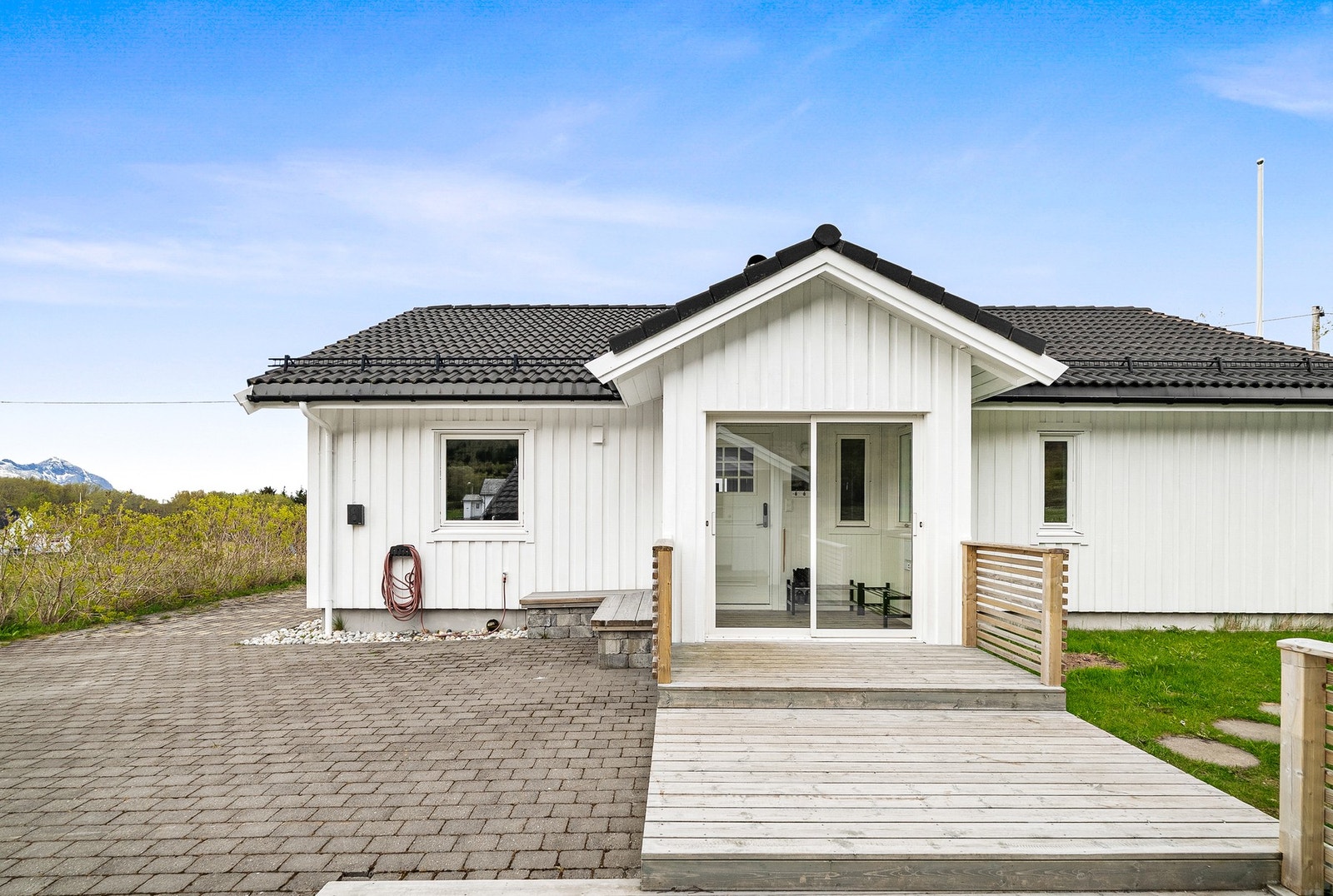 Boligens fasade har stående bordkledning, og taket er tekket med betongtakstein. Galleribilde