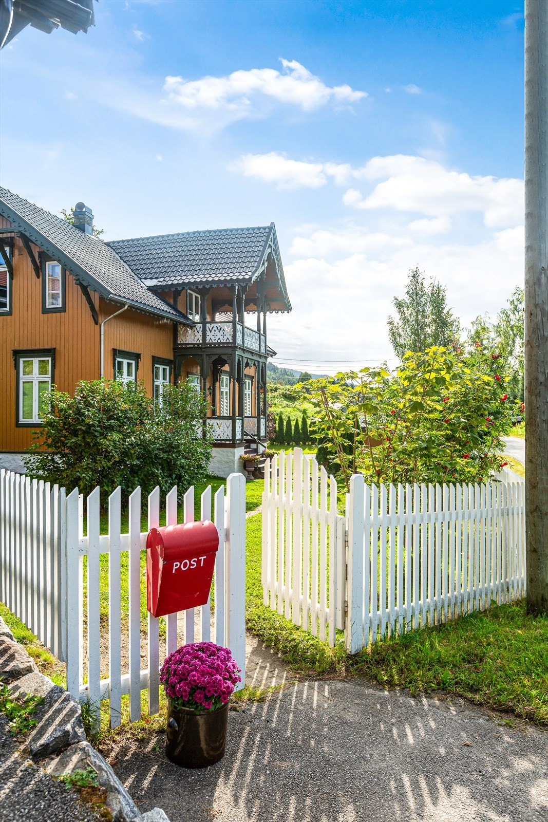 Det hvite stakittgjerde inviterer inn til et hyggelig tun. Galleribilde