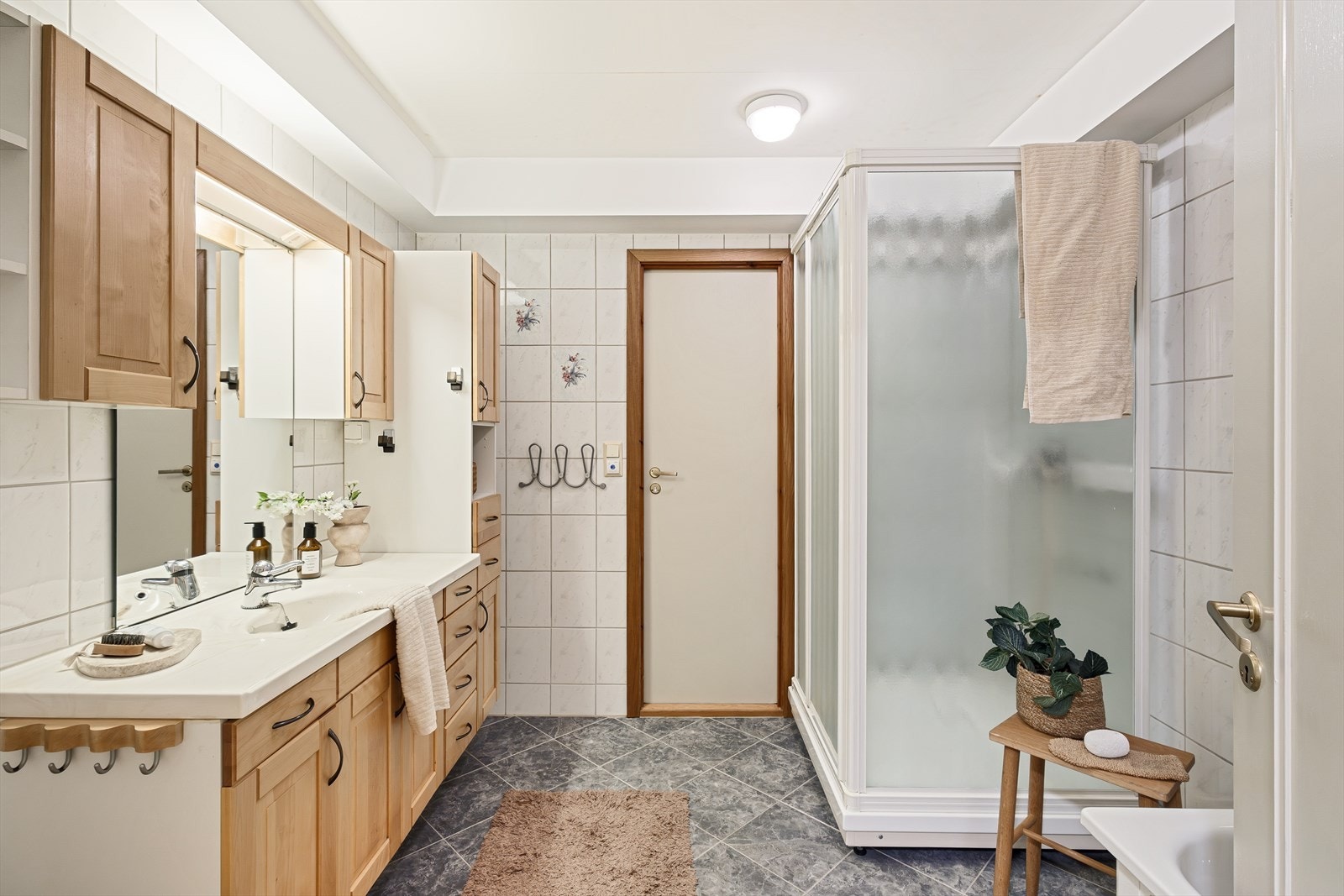 Badet er helfliset og er innredet med nedfelt servant, badekar, dusjkabinett og toalett. Galleribilde