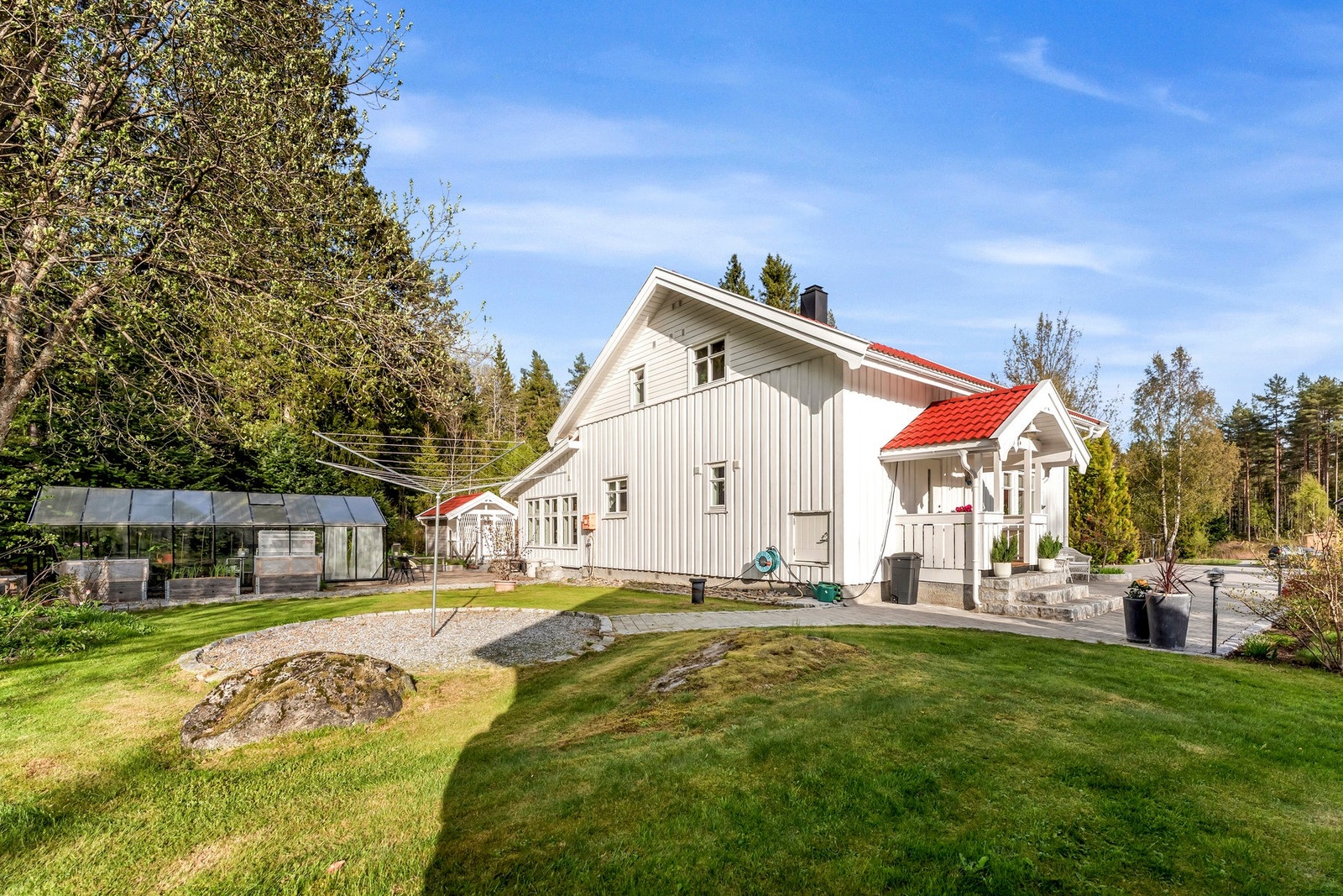 På baksiden av huset har man tilgang til drivhuset, tørkestativ, uthus for ekstra lagring og utedo. Galleribilde