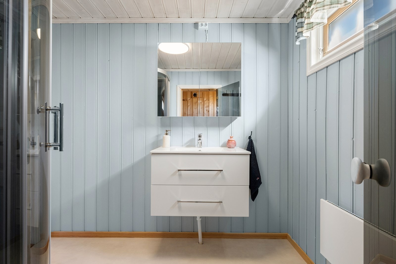 Badet er innredet med servantinnredning og dusjkabinett. Galleribilde