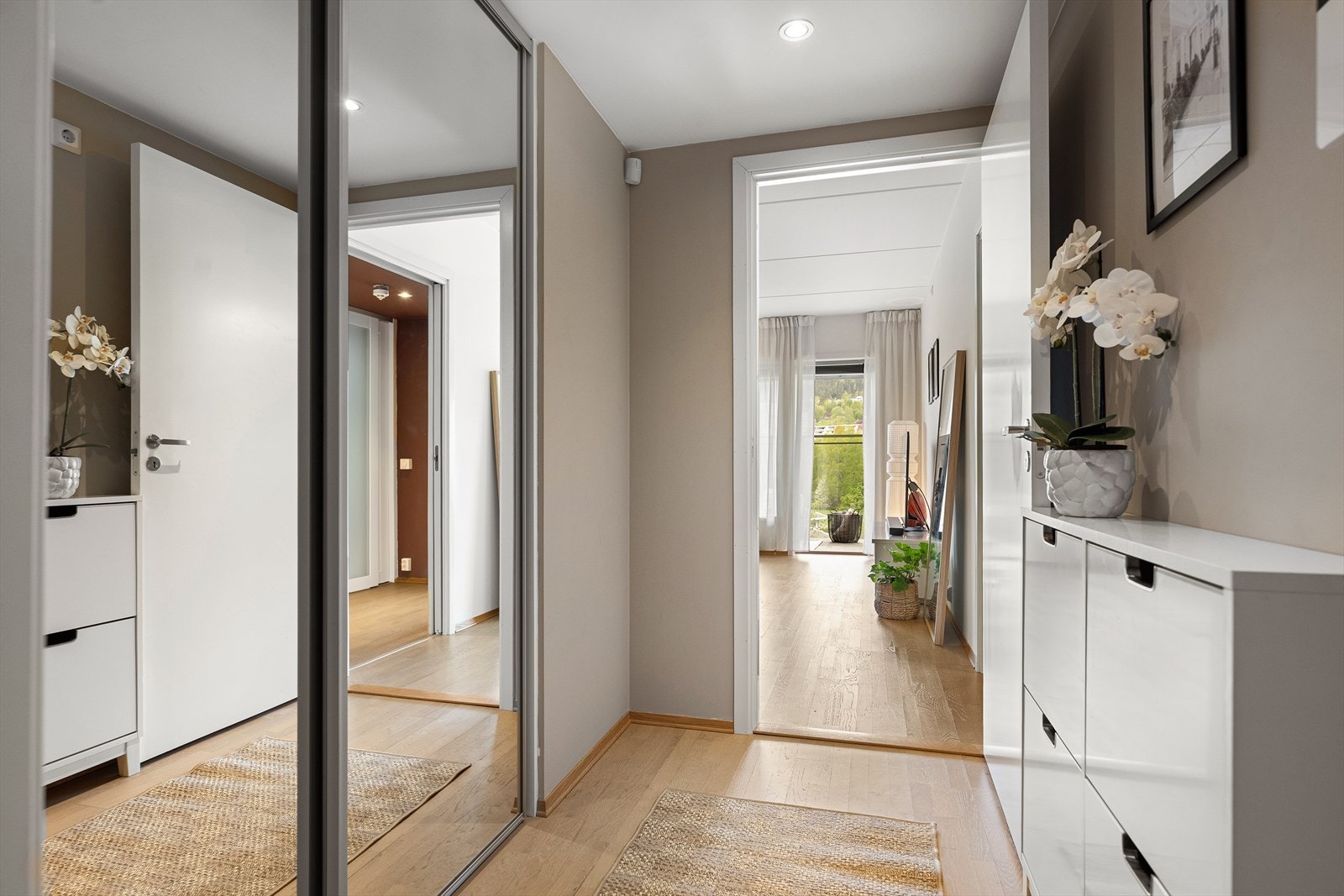 En romslig skyvedørsgarderobe med speilfronter gir rikelig med oppbevaringsplass for yttertøy og sko. Galleribilde