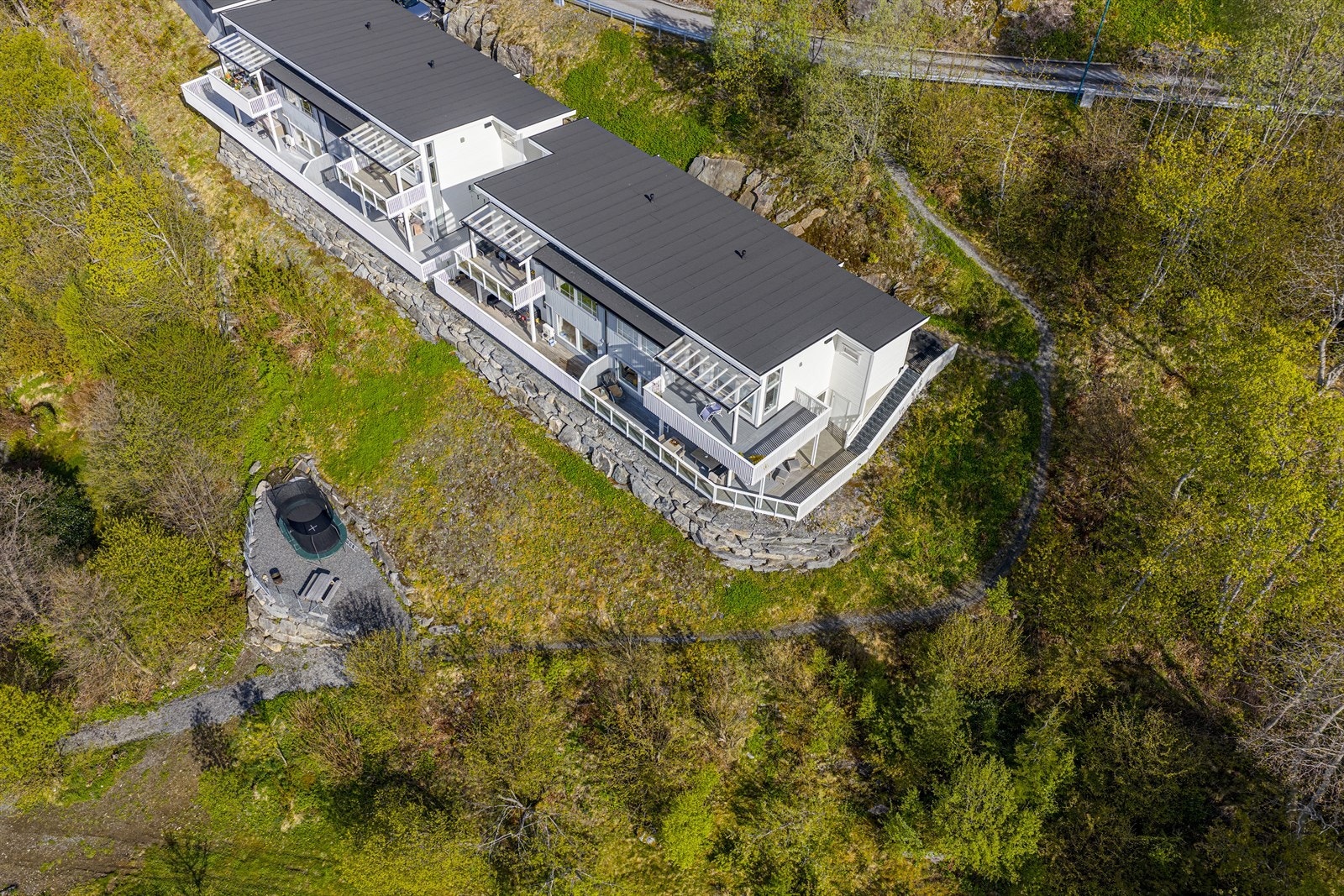 På fellesområdet er det opparbeidet en uteplass med benk og plass for trampoline Galleribilde