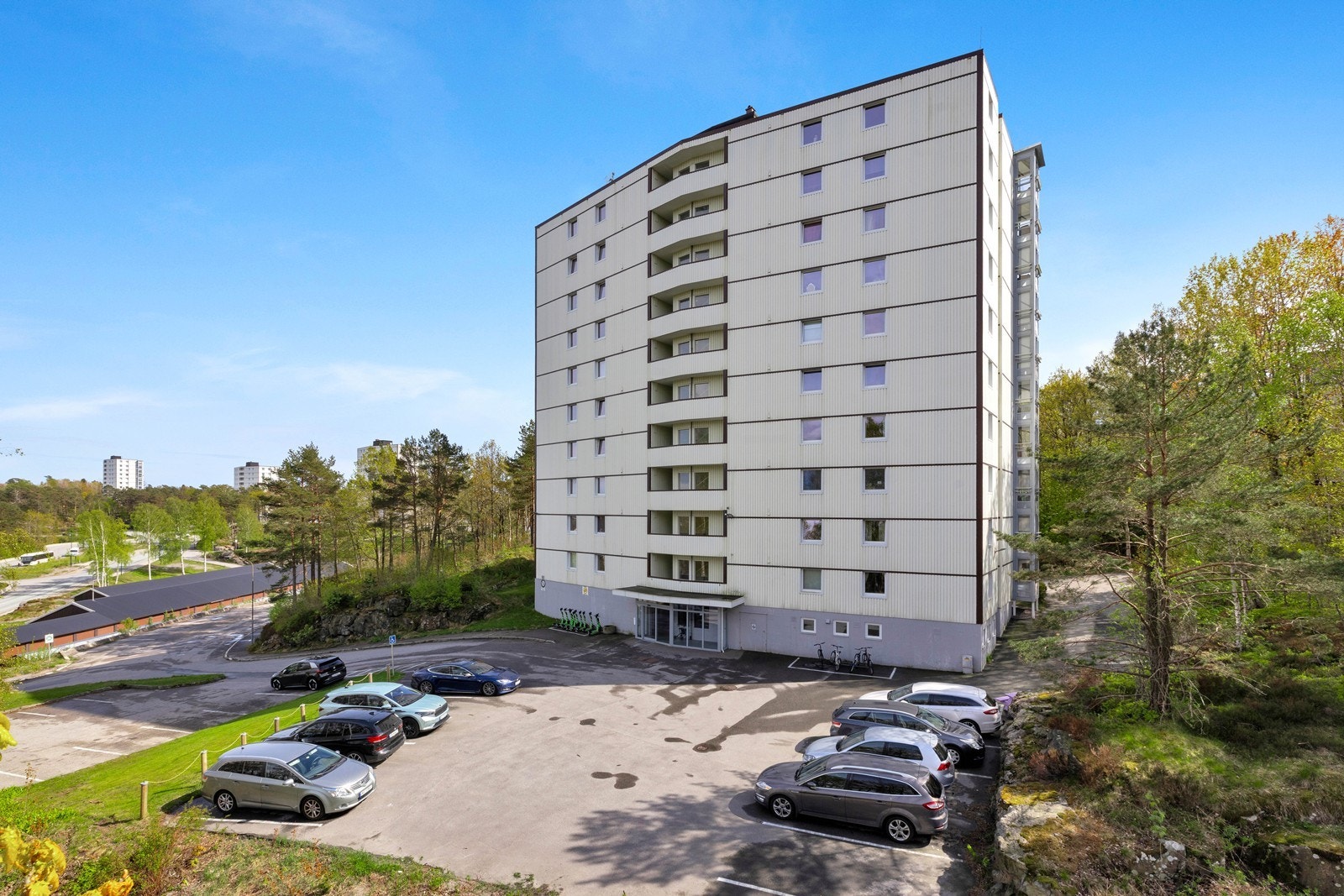 Med leiligheten følger garasje i rekke (til venstre i bildet) og det er ellers god plass til parkering foran boligblokken. Galleribilde