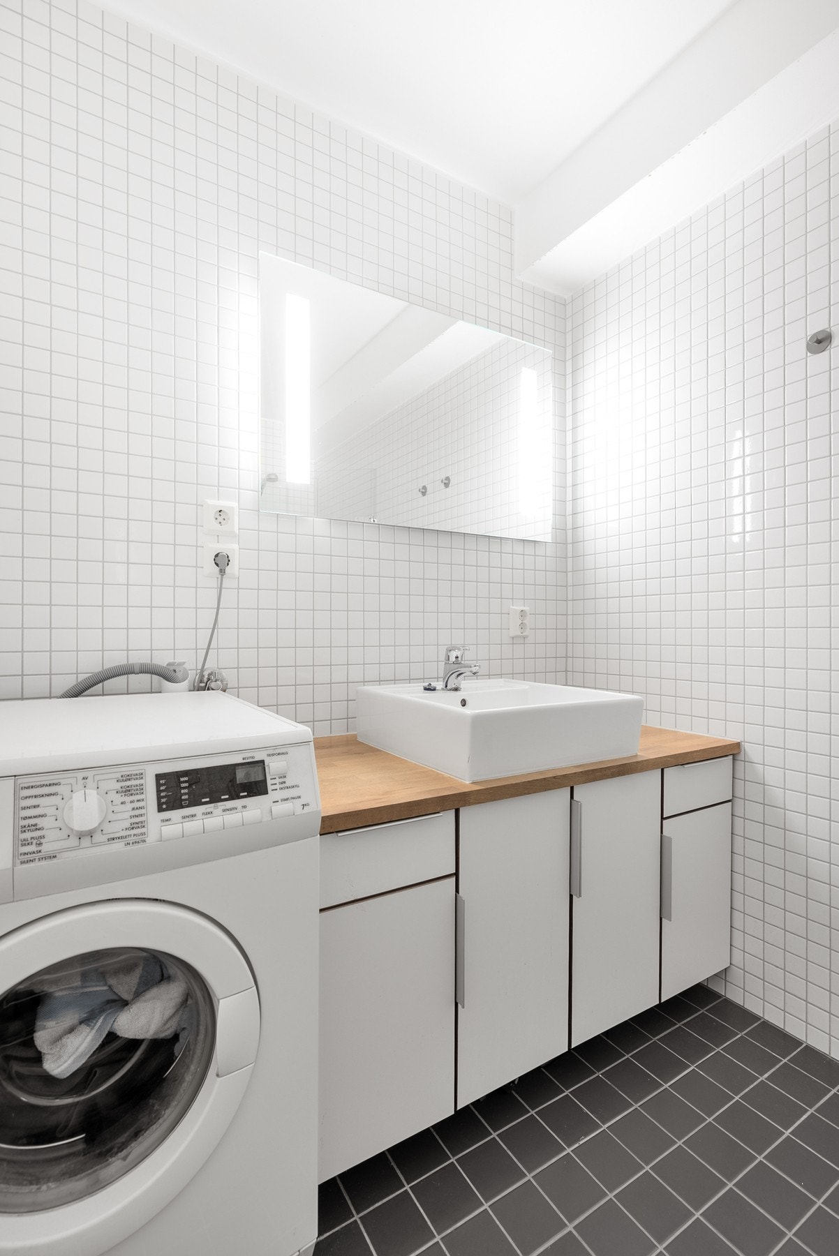Badet er helfliset med varmekabler i gulvet og god skapplass i servantinnredningen, som gir en funksjonell og komfortabel løsning Galleribilde