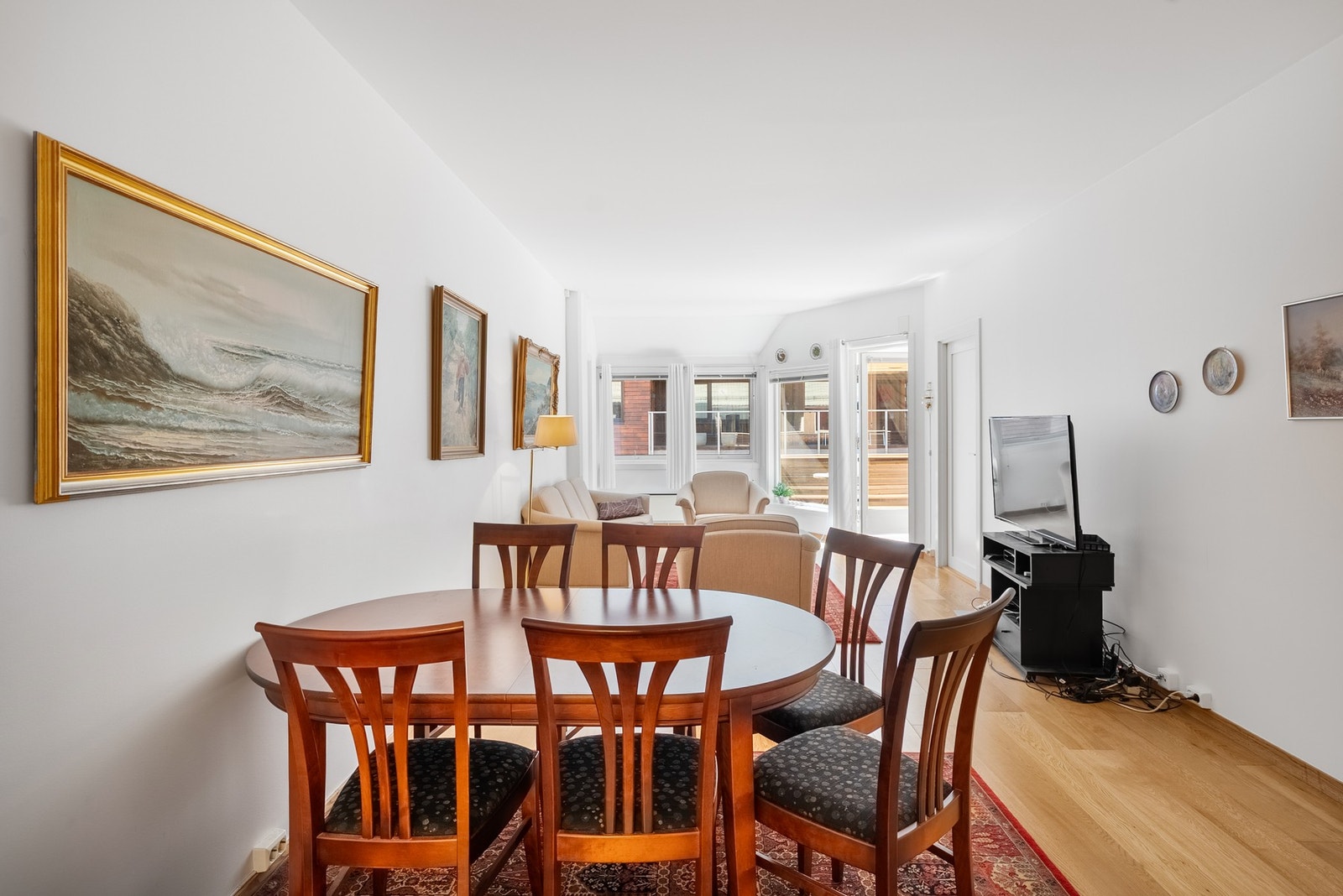 Stuen gir god plass til både spisestue og sofagruppe, med store vinduer i enden av rommet som slipper inn rikelig med lys Galleribilde