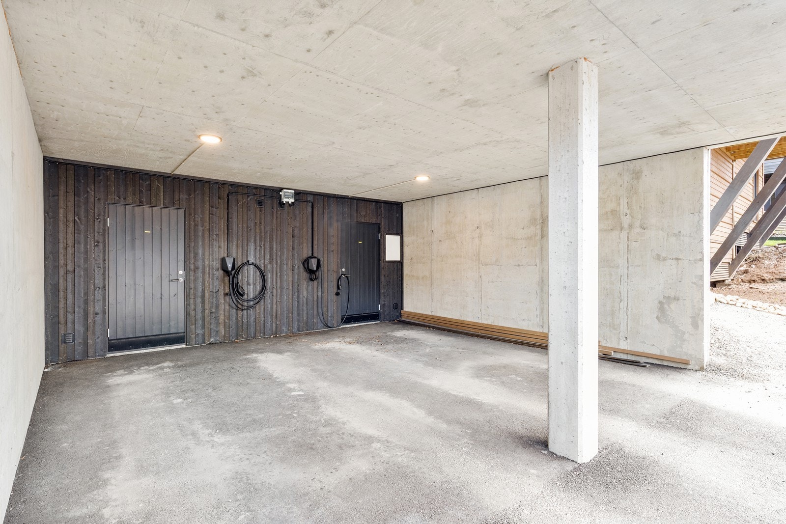 Carport og sportsbod i underetasjen. Det er carporten til venstre i bildet som tilhører boligen, den til høyre tilhører naboeiendom. Elbillader er montert. Galleribilde