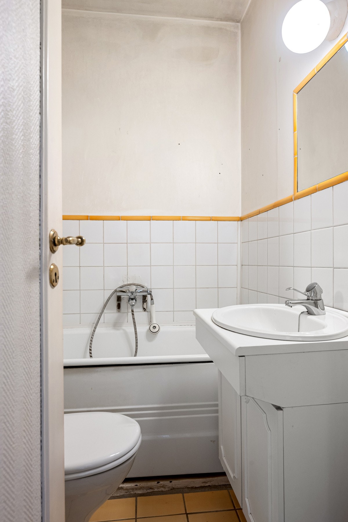 Badet inneholder servant med innredning, toalett og badekar med dusjløsning. Galleribilde