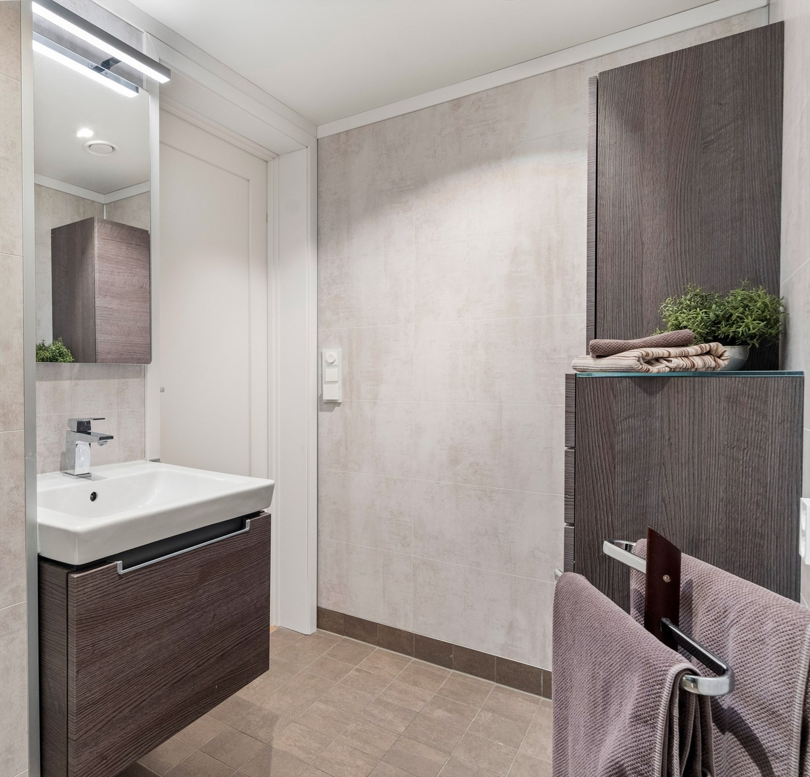 Romslig innredning under servant og med to skap. Speil med varme mot dugg. Galleribilde