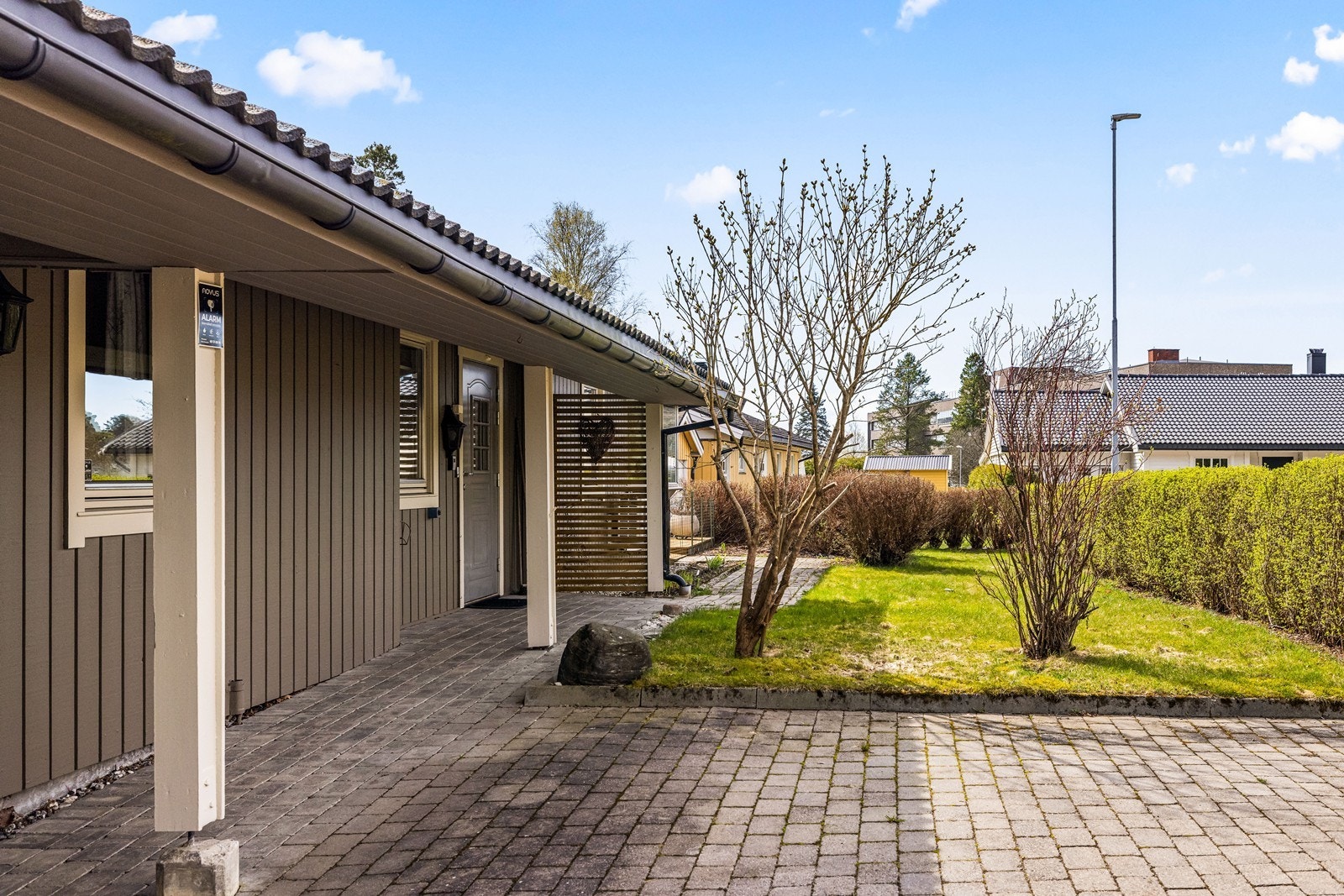 Eiendommen har en pent opparbeidet og steinlagt gårdsplass frem til et overbygd inngangsparti. Galleribilde