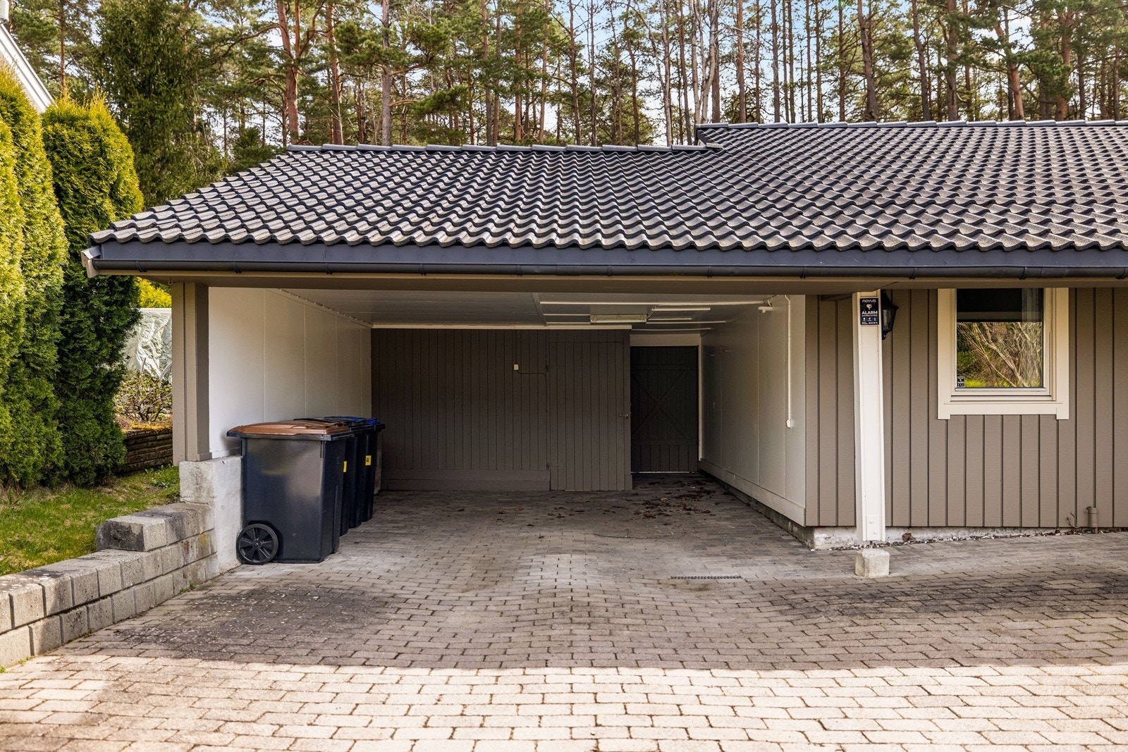 Integrert carport med tilhørende bod gir praktisk, overbygd parkering og ekstra lagringsplass. Galleribilde