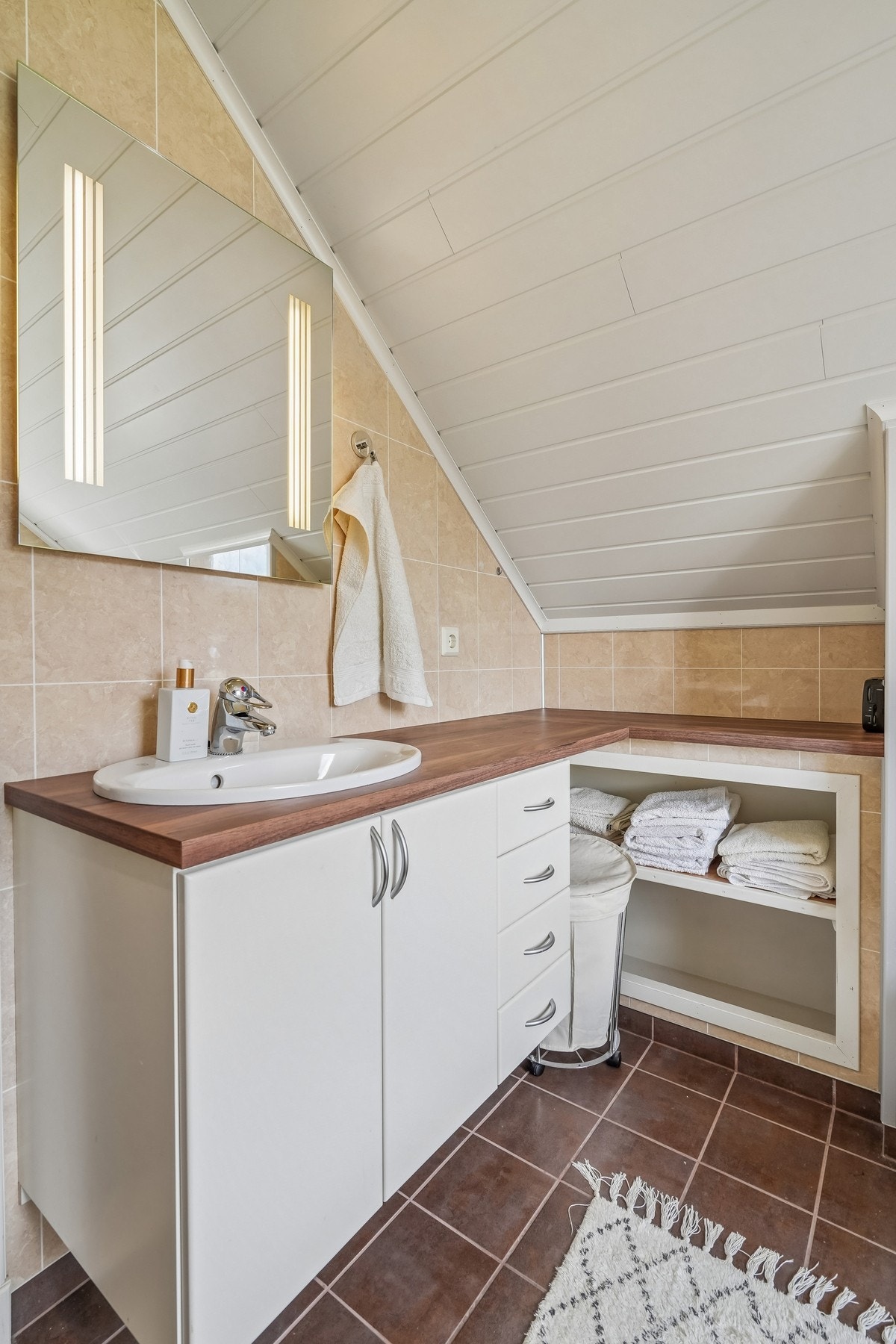 Baderomsinnredning med nedfelt servant, laminat benkeplater og speil med integrert belysning. Galleribilde