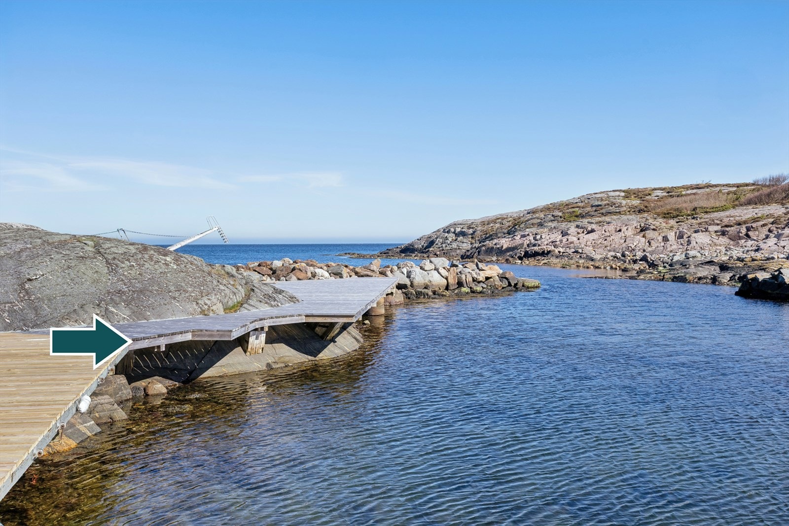 Båtplassen er markert med pil og har utriggere på hver side som tas inn for vinteren. I bakgrunnen sees Tønsberg bryggen som tilhører fellesområdet og brukes til bading. Galleribilde
