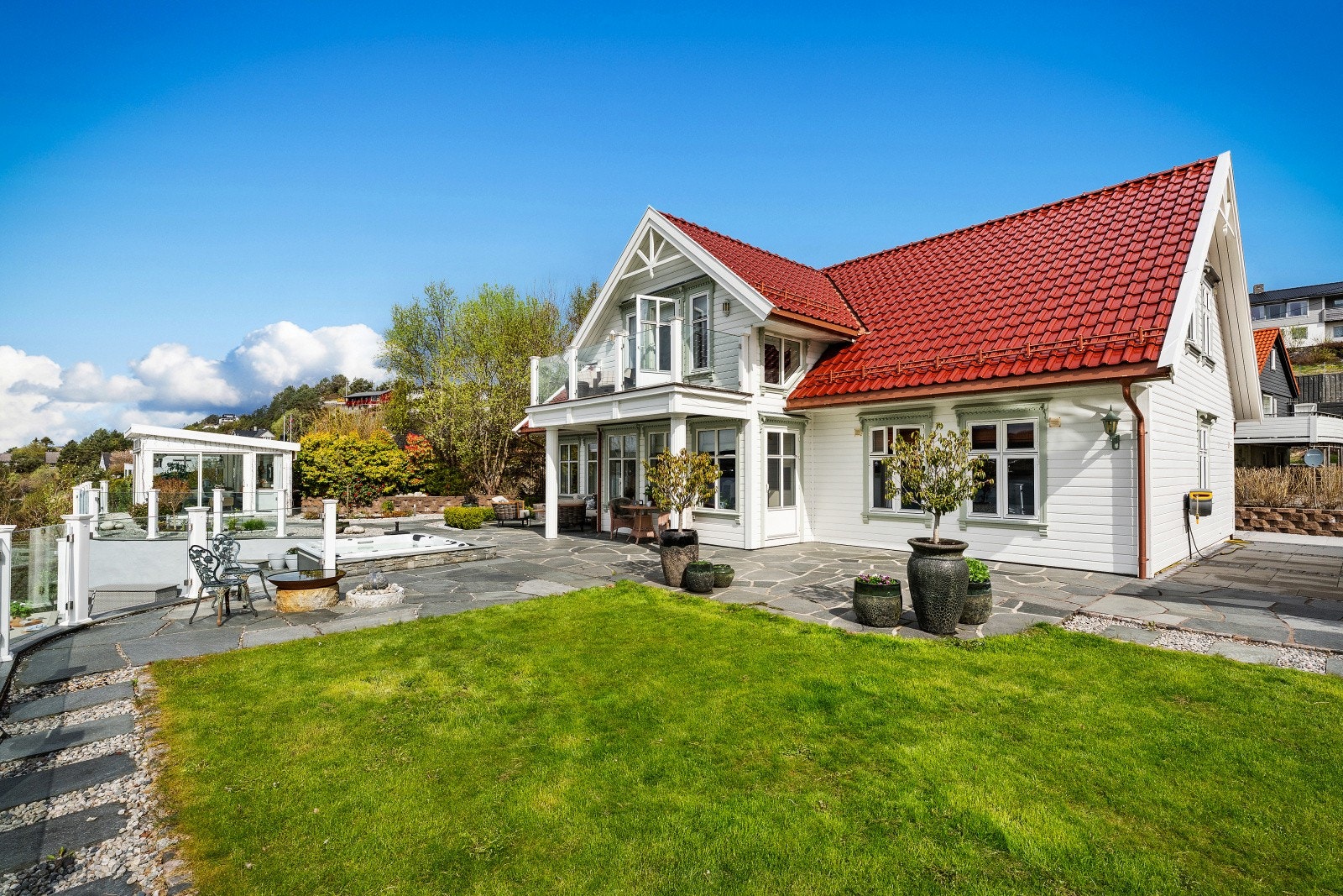Flat og velstelt tomt opparbeidet for minimalt vedlikehold. Boligen har glassert takstein og stålrenner og nedløp. Galleribilde