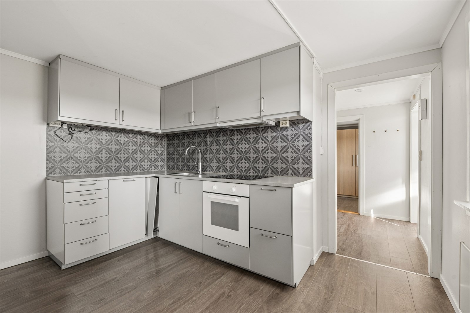 Det flotte kjøkkenet har en delvis åpen løsning mot stuen og fremstår med en tidsriktig kjøkkeninnredning med glatte fronter i lys utførelse fra IKEA, montert i 2015. Galleribilde