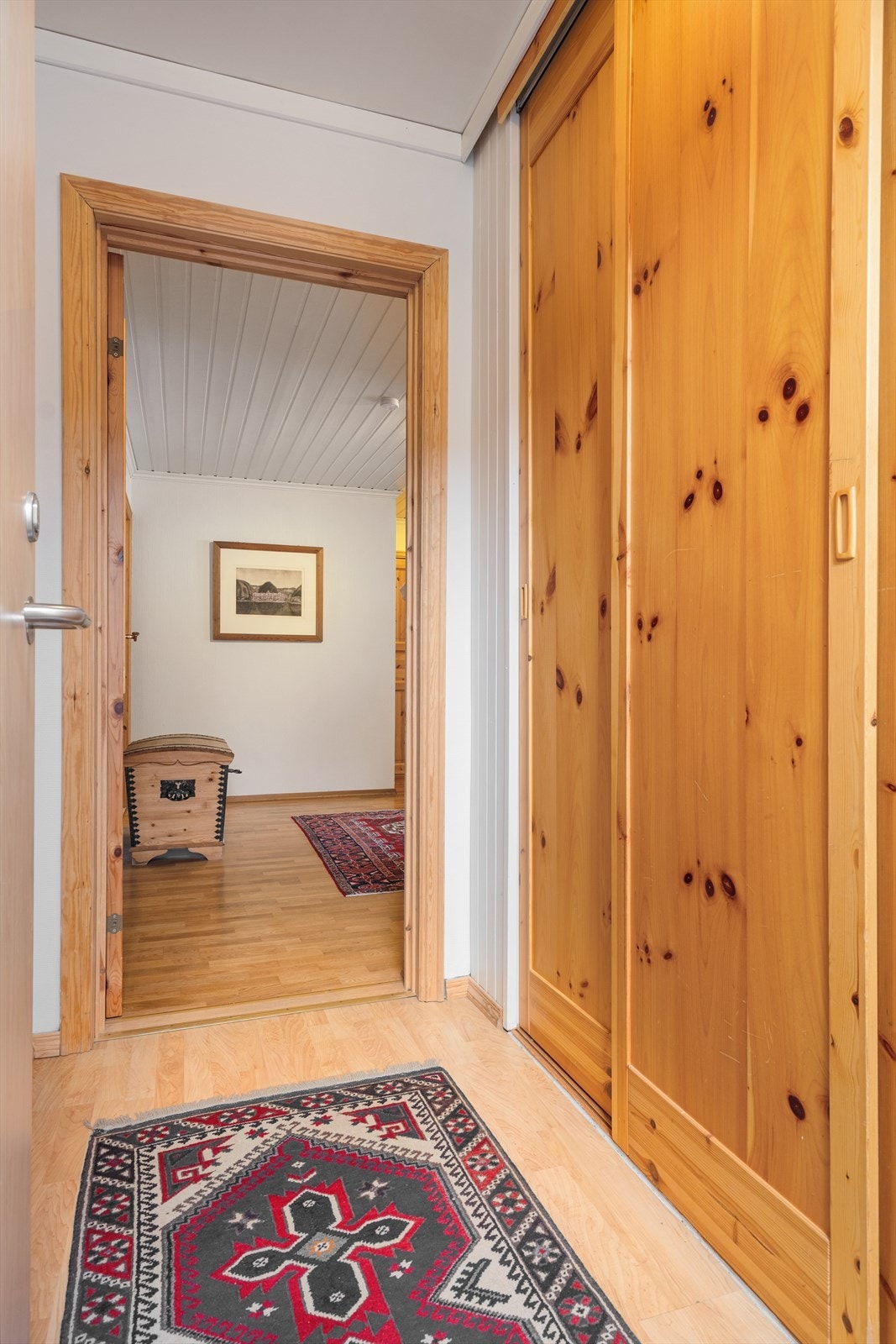 Velkommen inn. Det første man kommer til er leilighetens entre med en praktisk skyvedørsgarderobe. Galleribilde