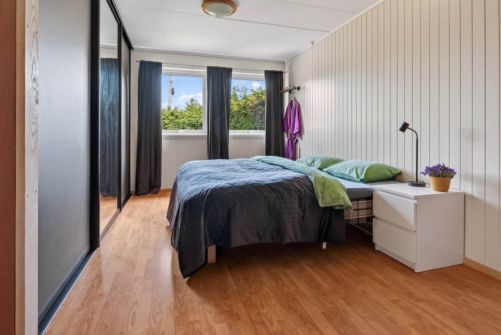 Ett av to soverom i underetasjen, utstyrt med en stor skyvedørsgarderobe. Galleribilde