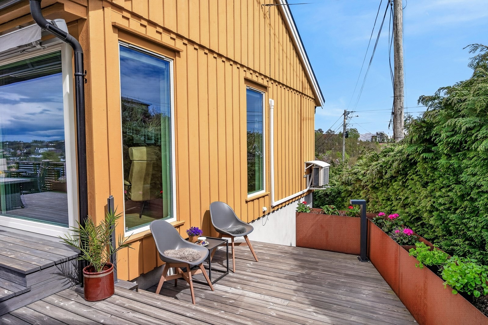 Detaljer fra uteområdet, med moderne plantekasser i cortenstål og god plass til sittegrupper. Galleribilde