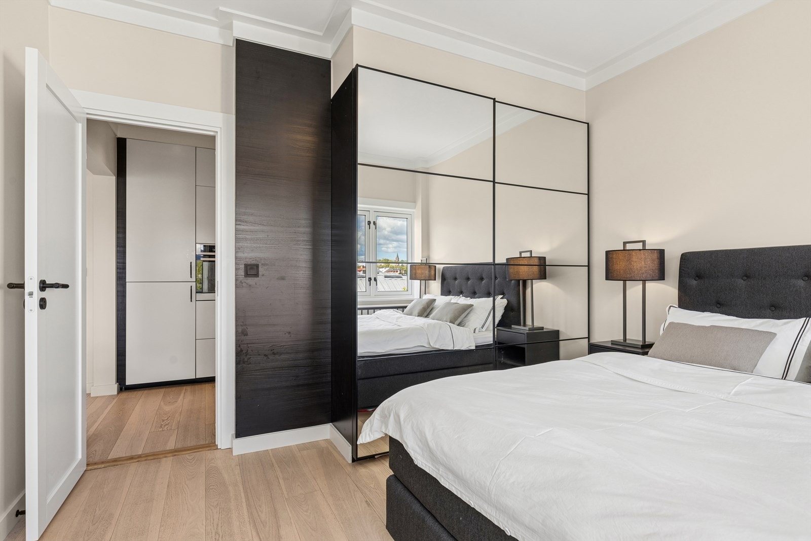 Fra kjøkkenet har man inngang til en stort soverom med skyvedørsgarderobe. Det er også plass til skrivebord på soverommet. Galleribilde