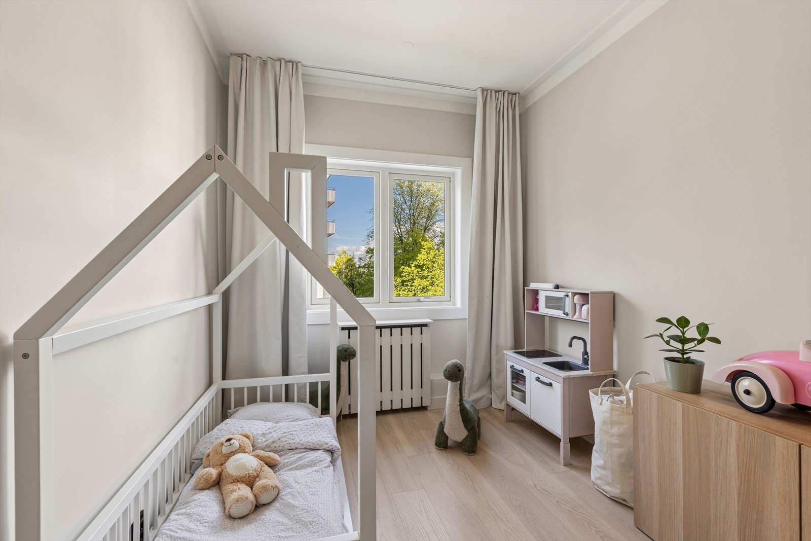 Lyst barnerom/gjesterom med vindu med stille bakgård. Det er plass til seng, skrivebord og garderobe på soverommet. Galleribilde