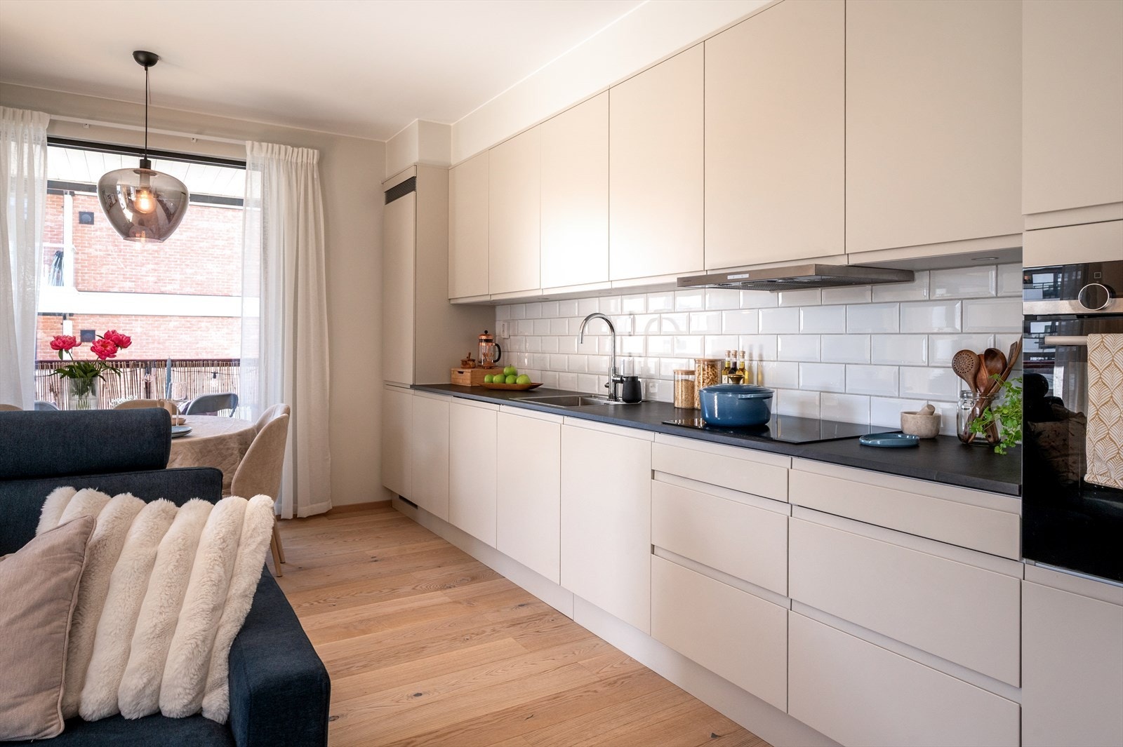 Moderne kjøkken i åpen løsning mot stuen som gir en sosial og luftig romfølelse. Kjøkkeninnredningen er fra Sigdal og har stilrene, glatte fronter med integrerte håndtak. Galleribilde