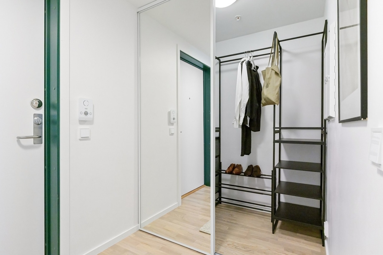 Entréen/gangen har et praktisk garderoberom/walk-in closet med skyvedører og speilfronter som gir rikelige med oppbevaringsmuligheter. Galleribilde