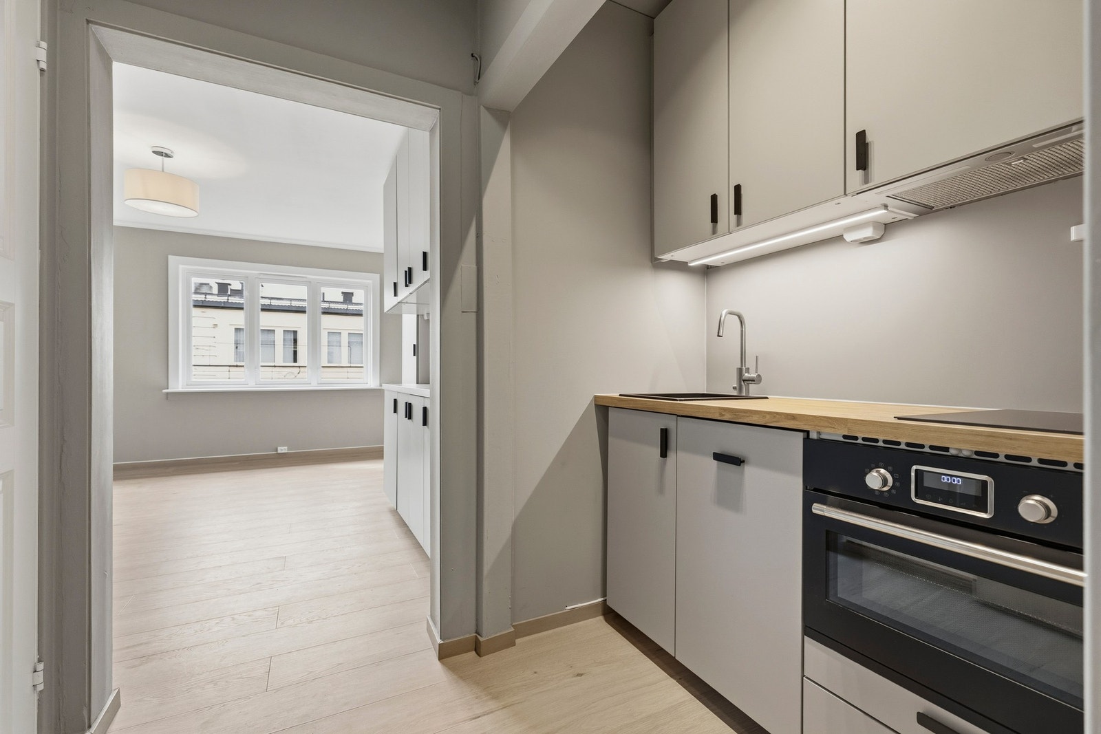 Her får du en innredning med laminat benkeplater, flislagt backsplash og glatte fronter som gir et tidløst preg. Galleribilde