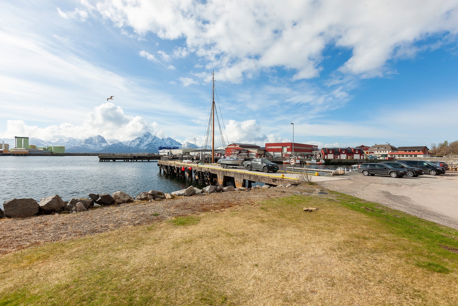 Nærområde med sjø, brygge og fjell i bakgrunnen. Galleribilde
