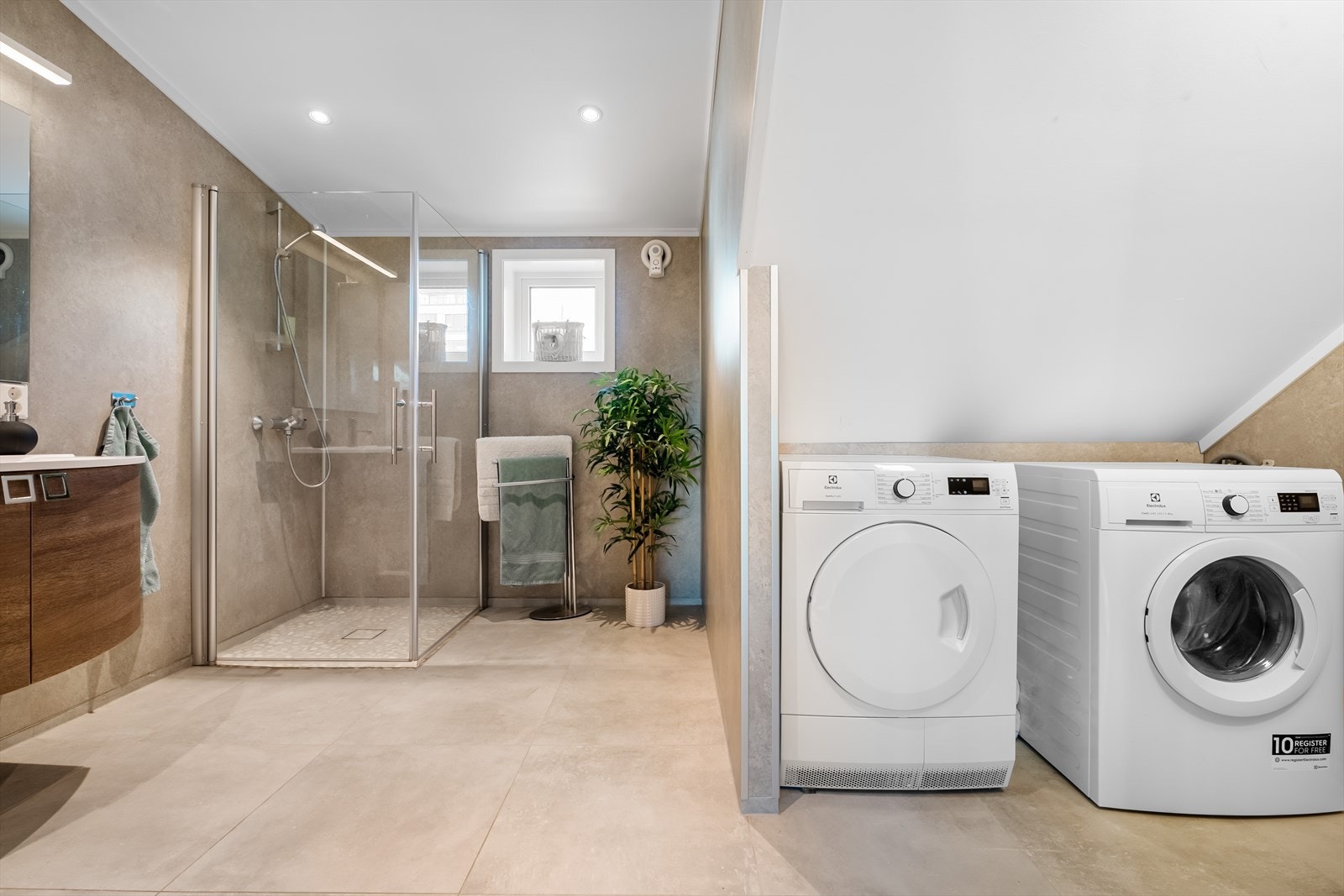 Badet har dusjhjørne, toalett, servantmøblement, samt opplegg for vaskemaskin og tørketrommel. Galleribilde