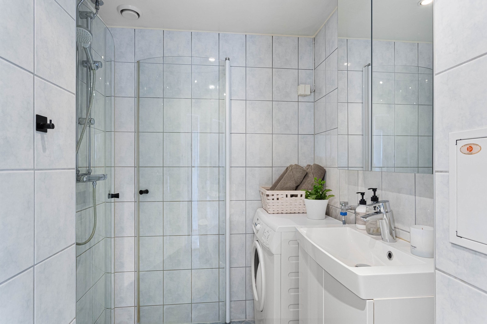 Flislagt bad med elektrisk gulvvarme og opplegg for vaskemaskin. Galleribilde