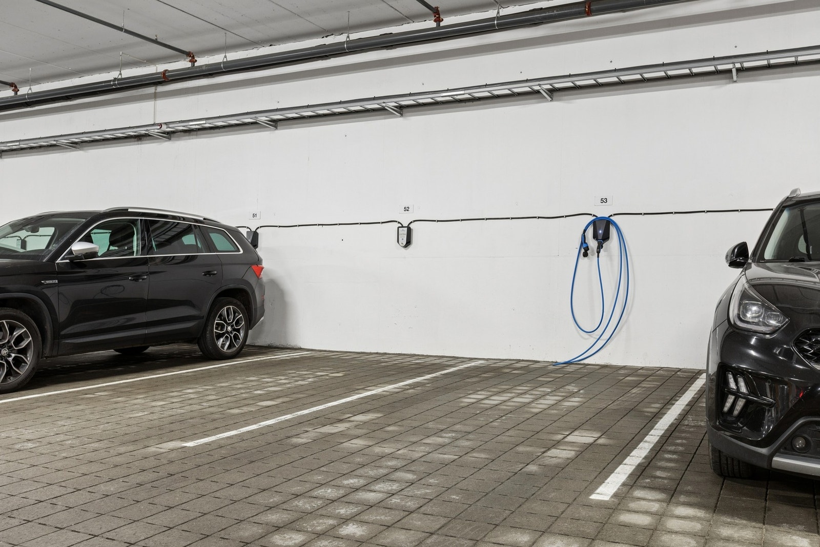 Parkering i felles garasjekjeller. Biloppstillingsplassen har lader for elbil. Galleribilde