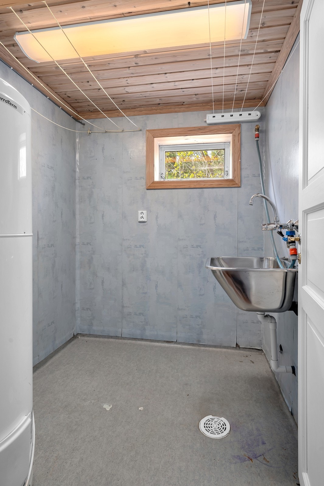 Rommet har våtromsbelegg med oppkant på gulv og opplegg for vaskemaskin. Galleribilde