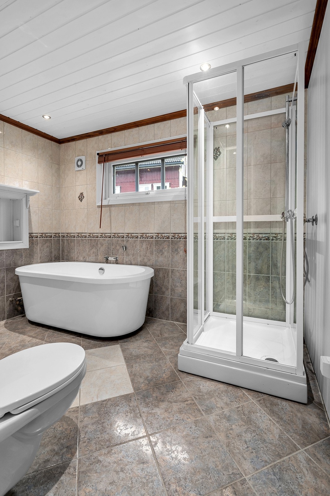 Badet i hovedetasjen er utstyrt med fliser på gulv og vegger, samt malte panelplater av MDF. Galleribilde