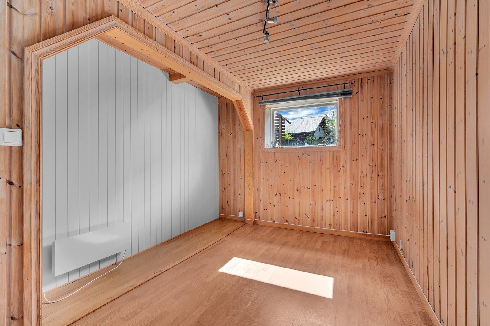Rommet har vegger av furupanel og laminatgulv, med standard belysningsløsning. Galleribilde