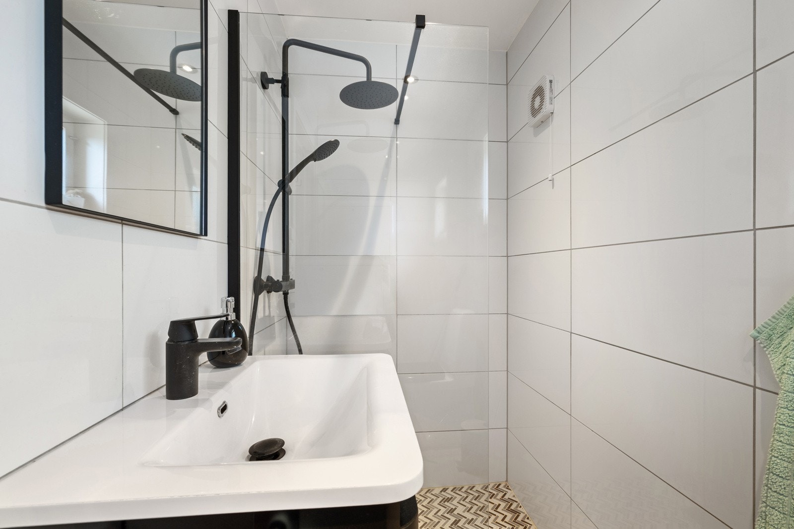 Badet er innredet med servantinnredning, toalett og dusjhjørne. Galleribilde