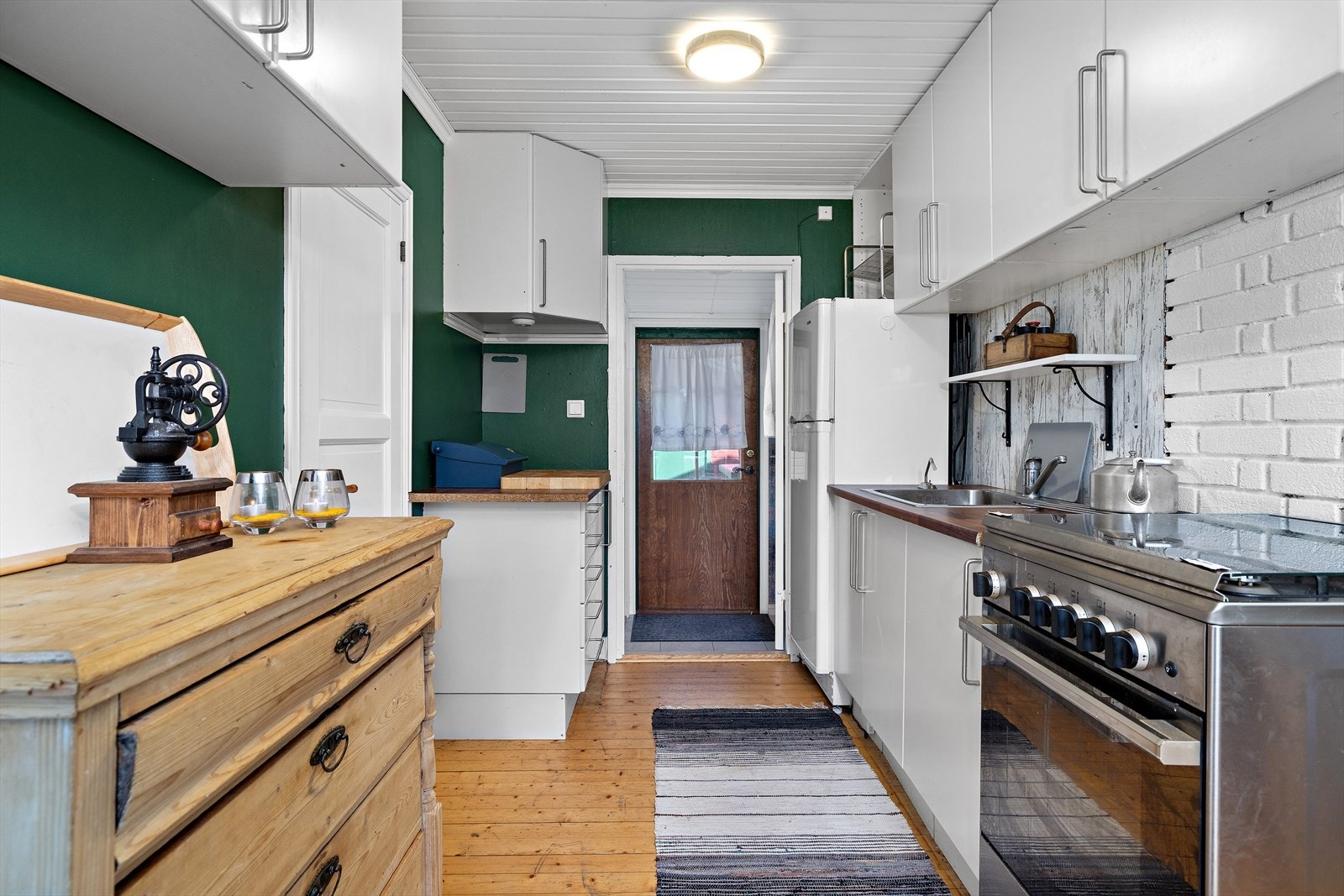 Kjøkkeninnredning med glatte fronter og benkeplate i laminat. Gråvann fra kjøkkenkum føres ut av hytta. Galleribilde
